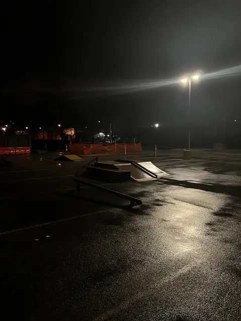 Night falls, leaving the skatepark wet and waiting.